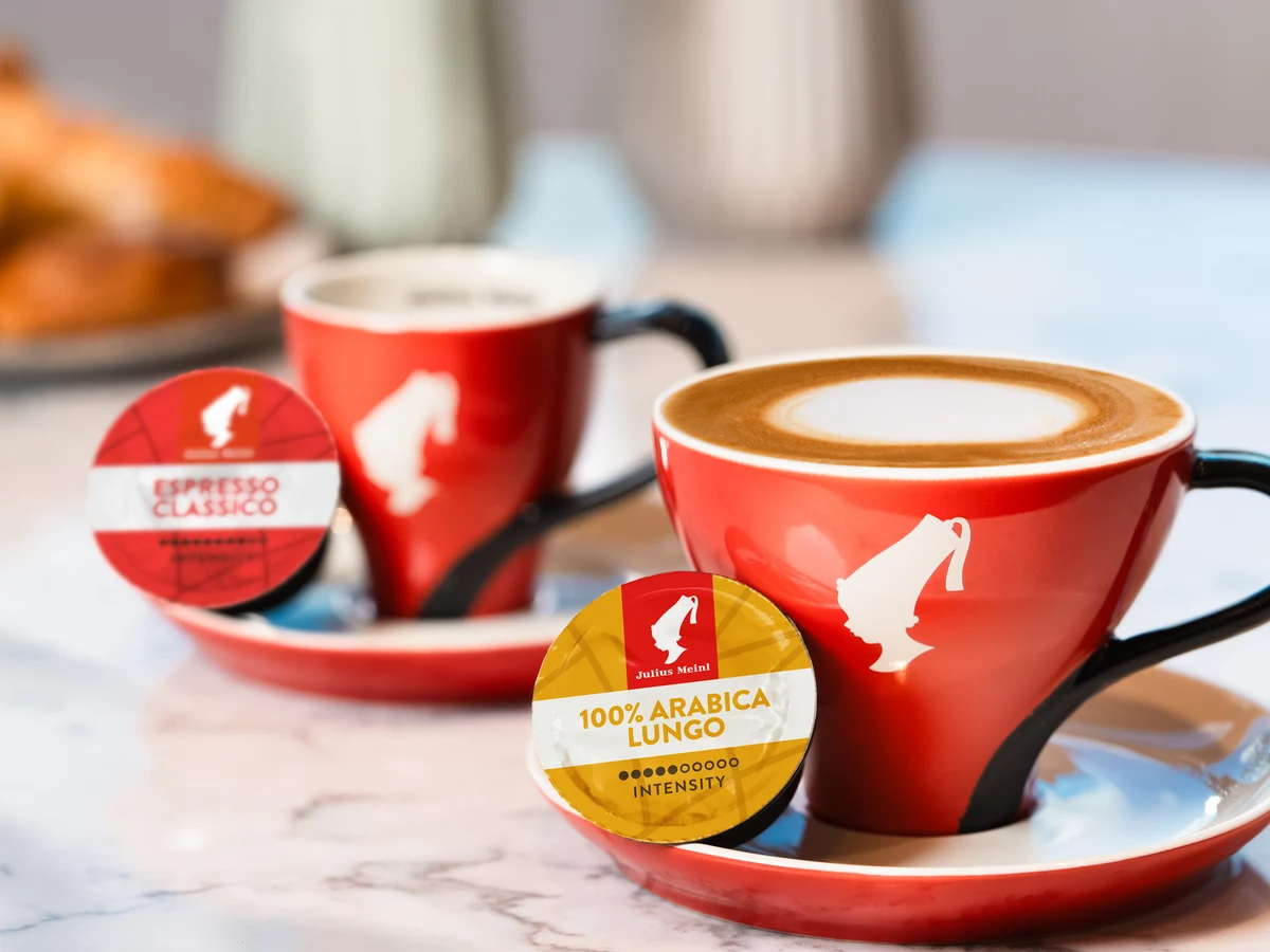 Julius Meinl šalice espressa i kapsule na stolu